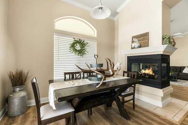 21623 Seven Lakes Ln, Redding, CA 96003 - dining space with baseboards, crown molding, wood finished floors, and a multi sided fireplace