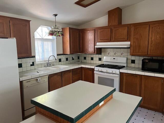 8725 Rocky Mountain Rd, Shingletown, CA 96088 - kitchen featuring vaulted ceiling, a sink, white appliances, light floors, and under cabinet range hood