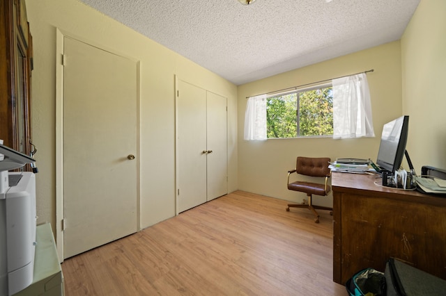 office area with a textured ceiling and light wood-style flooring