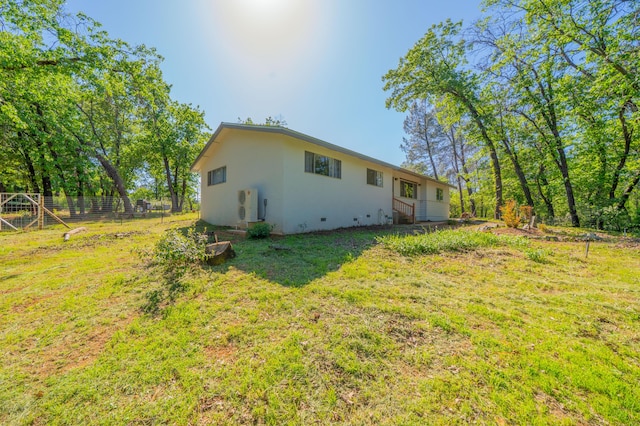 rear view of house with a lawn and fence