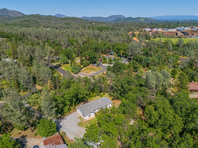 birds eye view of property with a wooded view and a mountain view