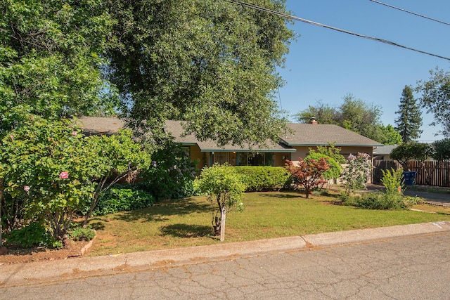 view of front of property with fence, a chimney, and a front yard