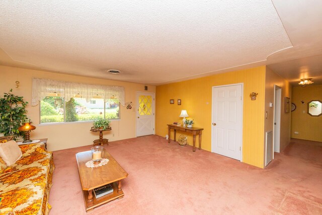 living area with carpet, a textured ceiling, and visible vents