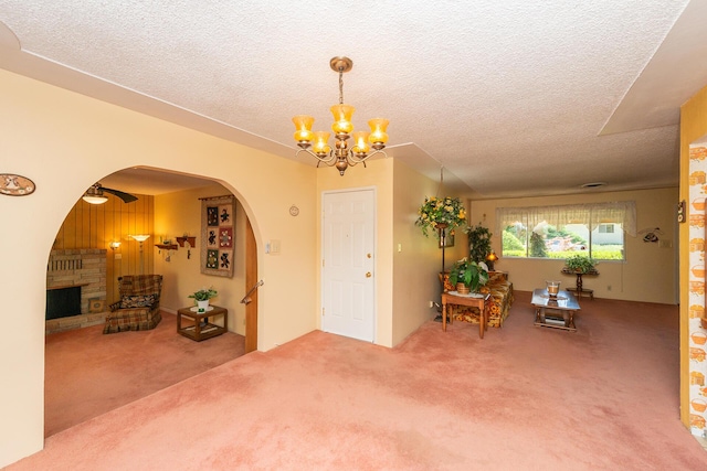interior space featuring a textured ceiling, carpet floors, and a notable chandelier
