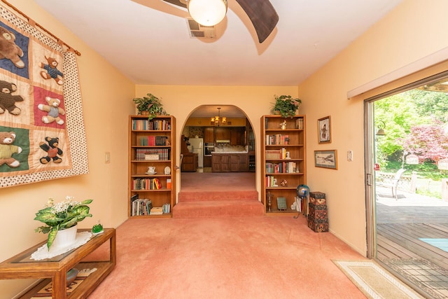corridor featuring arched walkways, carpet floors, and visible vents