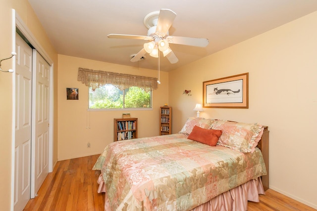 bedroom featuring light wood-style flooring, baseboards, a closet, and ceiling fan