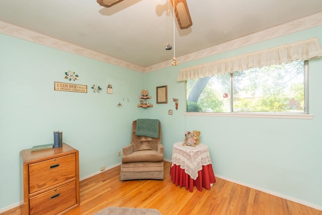 sitting room with baseboards, a ceiling fan, and wood finished floors