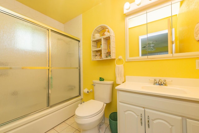 full bath featuring bath / shower combo with glass door, toilet, vanity, and tile patterned floors