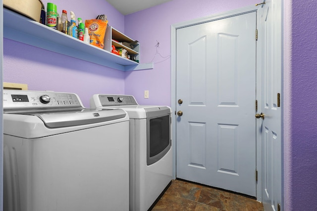 laundry area featuring stone finish floor, laundry area, and separate washer and dryer