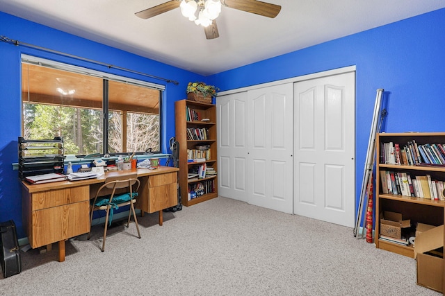 carpeted home office featuring ceiling fan