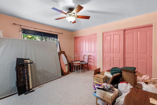 carpeted bedroom featuring two closets and ceiling fan