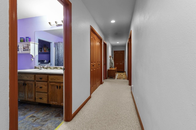 hallway with recessed lighting and baseboards