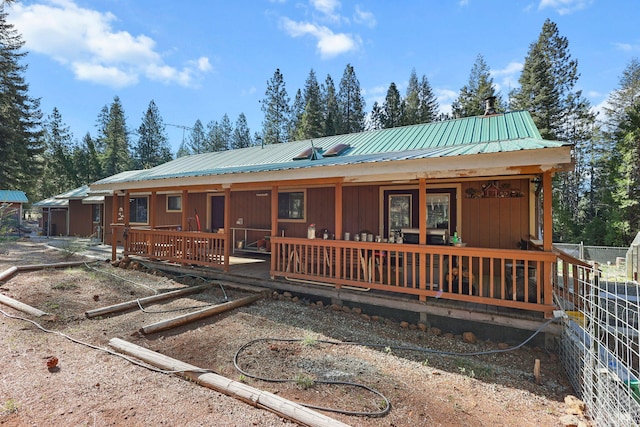 back of house featuring a porch and metal roof