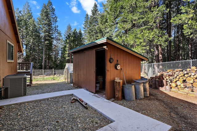 view of greenhouse featuring a shed, central AC, and a fenced backyard
