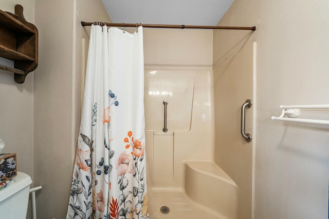 full bath with toilet and a stall shower