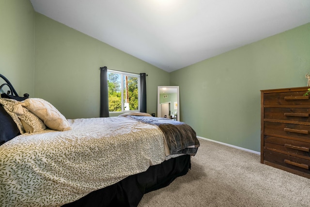 carpeted bedroom featuring lofted ceiling and baseboards