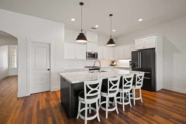 4631 Pleasant Hills Dr, Anderson, CA 96007 - kitchen with white cabinets, a sink, stainless steel microwave, arched walkways, and black fridge with ice dispenser