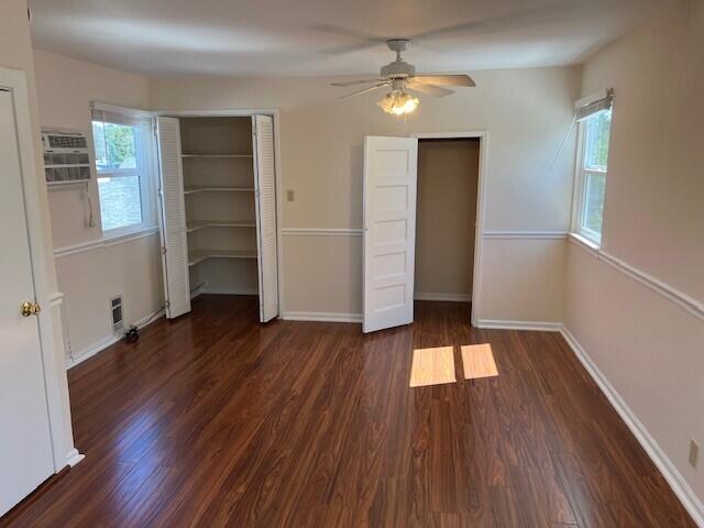 unfurnished bedroom with baseboards, visible vents, wood finished floors, and a ceiling fan