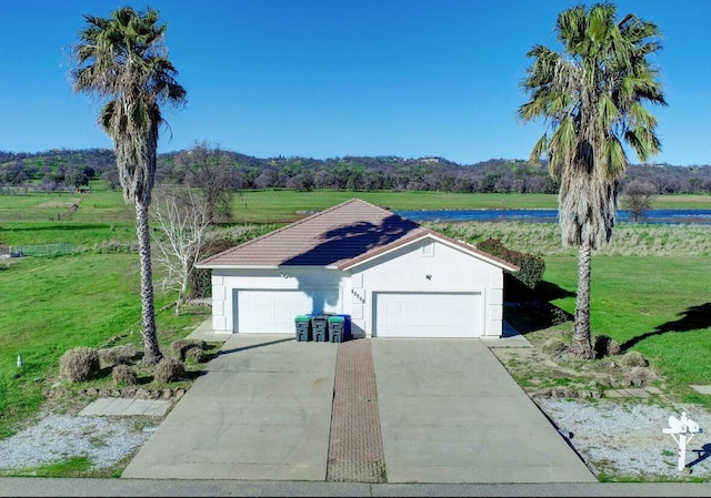 22496 Rio Alto Dr, Cottonwood, CA 96022 - view of front of property featuring a front yard, driveway, stucco siding, an attached garage, and a tile roof