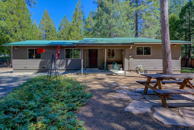 ranch-style house featuring crawl space, a patio area, outdoor dining space, and metal roof
