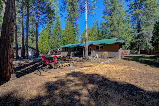 back of house featuring metal roof and fence