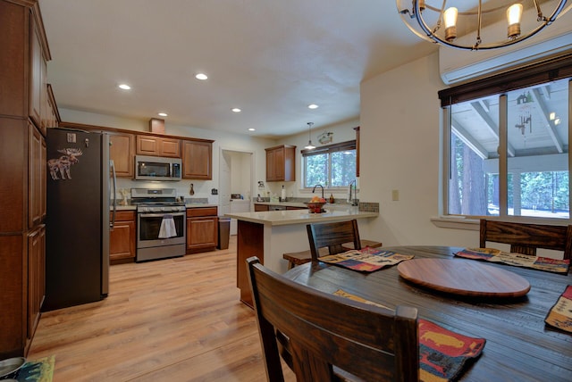 dining room with recessed lighting, a wall mounted air conditioner, light wood finished floors, and an inviting chandelier