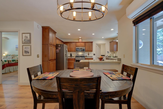 dining area with recessed lighting, baseboards, a chandelier, a wall mounted AC, and light wood-style flooring