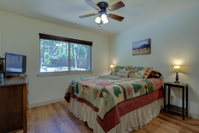 bedroom featuring baseboards, a ceiling fan, and wood finished floors