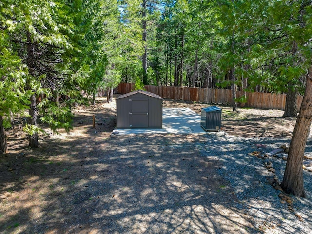 exterior space with fence, a storage unit, and an outbuilding