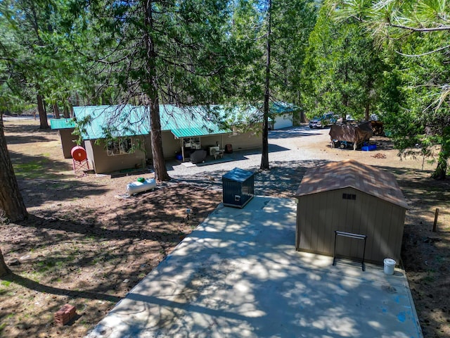view of yard featuring a patio area, an outdoor structure, and a storage unit