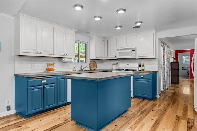 7090 Rio Rancho Rd, Anderson, CA 96007 - kitchen featuring blue cabinets, decorative backsplash, white cabinetry, and white appliances
