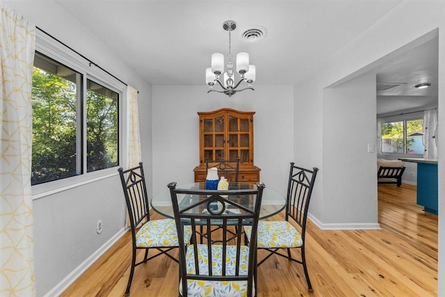 7090 Rio Rancho Rd, Anderson, CA 96007 - dining space featuring a chandelier, wood finished floors, visible vents, and baseboards