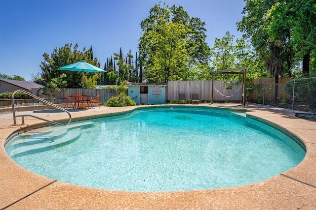 7090 Rio Rancho Rd, Anderson, CA 96007 - view of swimming pool featuring a fenced in pool, a fenced backyard, a patio area, an outdoor structure, and a storage unit