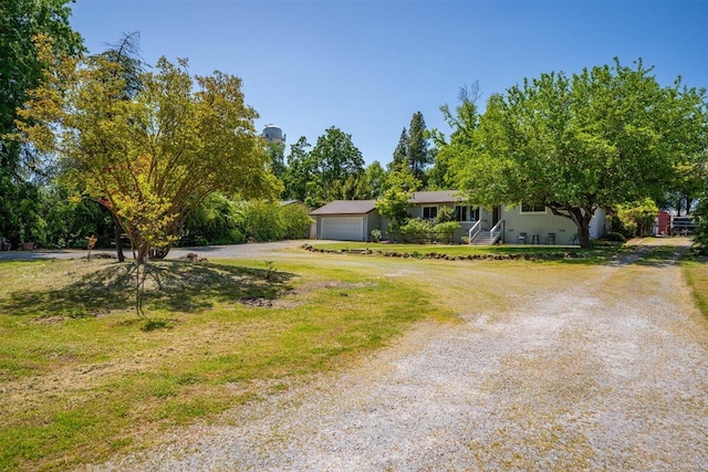 7090 Rio Rancho Rd, Anderson, CA 96007 - view of front of property featuring dirt driveway, an attached garage, and a front yard