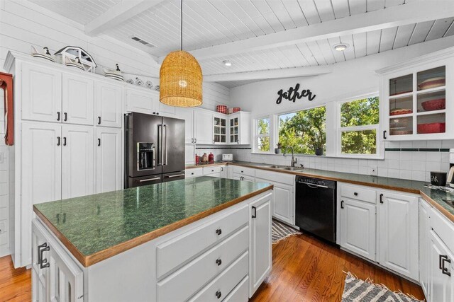 kitchen with dark wood finished floors, high end refrigerator, dark countertops, and black dishwasher