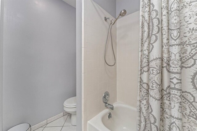 full bathroom with shower / tub combo, toilet, and tile patterned floors