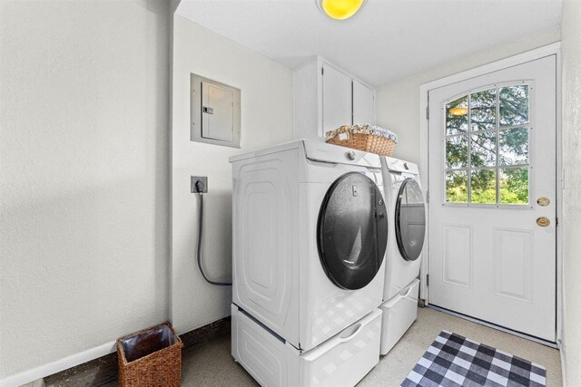 clothes washing area with washing machine and dryer, baseboards, cabinet space, and electric panel