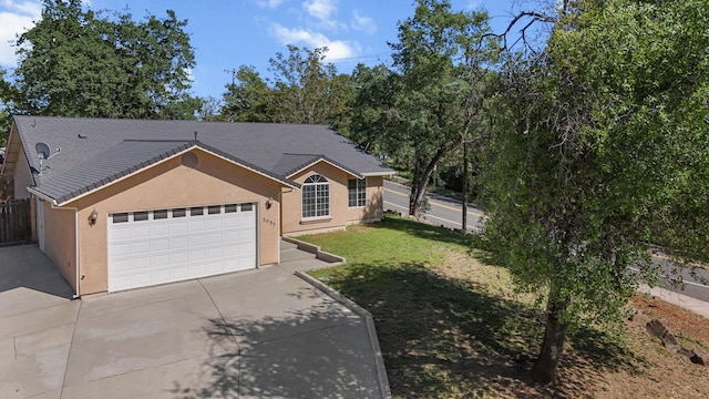 single story home with fence, stucco siding, concrete driveway, a front yard, and a garage