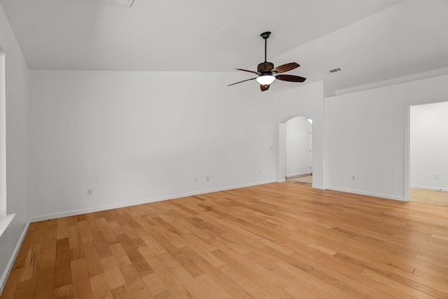 spare room featuring arched walkways, a ceiling fan, visible vents, and light wood finished floors