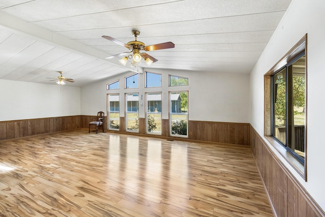 additional living space featuring wood finished floors, wood walls, and wainscoting