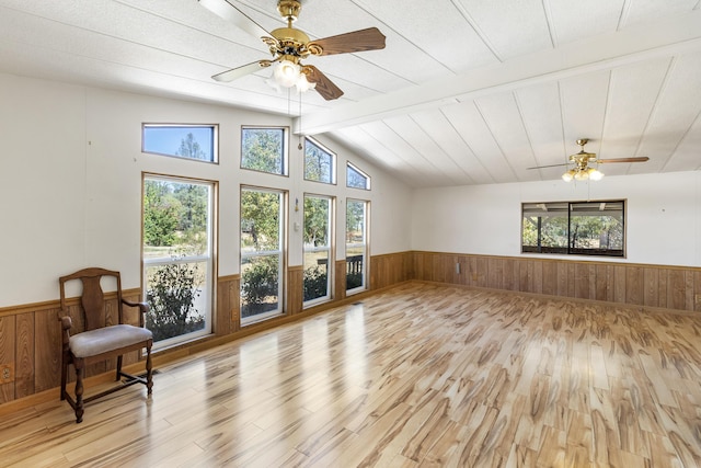 living room featuring plenty of natural light, a wainscoted wall, and wood walls
