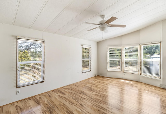 spare room with a wealth of natural light, a ceiling fan, wood finished floors, and lofted ceiling