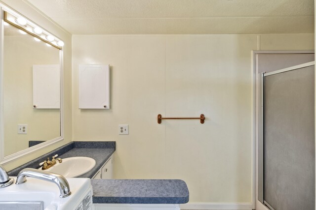 bathroom with a shower stall, a textured ceiling, and vanity