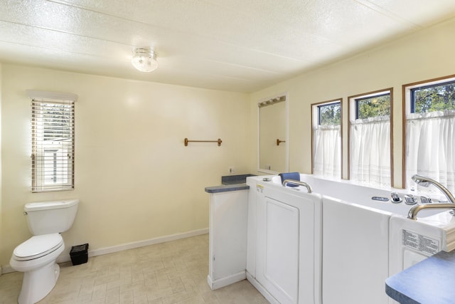 bathroom featuring toilet, tile patterned floors, and a healthy amount of sunlight