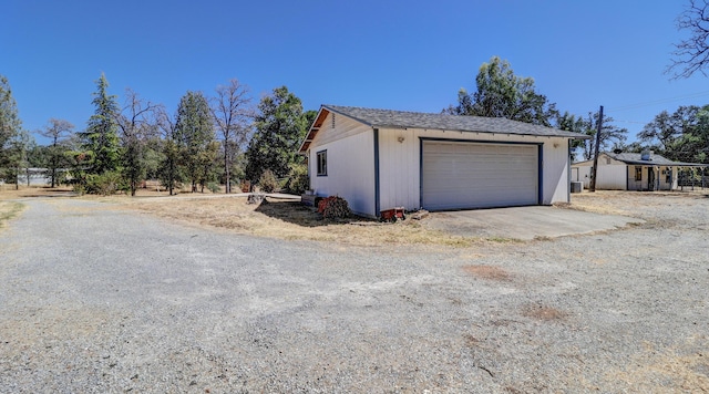 view of property exterior with an outdoor structure and a detached garage