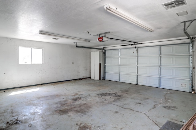 garage featuring a garage door opener and visible vents