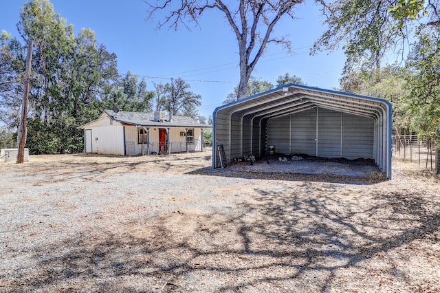 view of front of house featuring driveway, a carport, and fence
