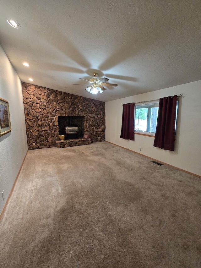 37150 Sapphire Rd, Burney, CA 96013 - unfurnished living room with a ceiling fan, carpet, a textured ceiling, and a stone fireplace