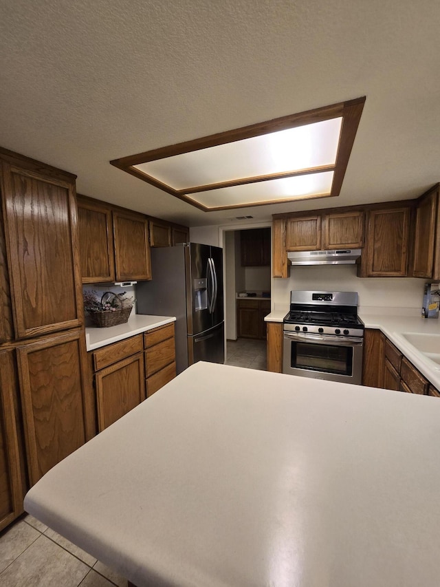 3671 Santa Rosa Way, Redding, CA 96003 - kitchen with under cabinet range hood, appliances with stainless steel finishes, light countertops, and light tile patterned floors