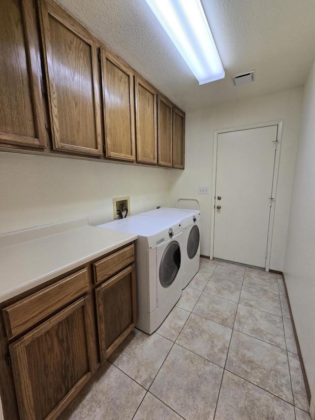 3671 Santa Rosa Way, Redding, CA 96003 - washroom with a textured ceiling, separate washer and dryer, light tile patterned floors, cabinet space, and visible vents